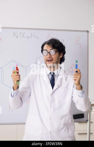 Young funny chemist in front of white board Stock Photo