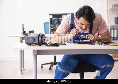 Young male contractor repairing computer Stock Photo