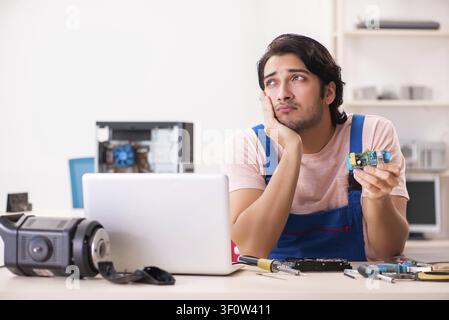 Young male contractor repairing computer Stock Photo