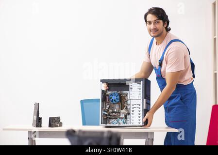 Young male contractor repairing computer Stock Photo