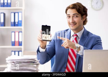 Deaf employee using hearing aid in office Stock Photo