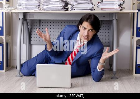 Young businessman employee unhappy with excessive work Stock Photo