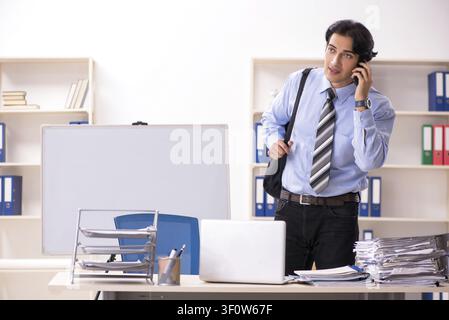 Young handsome male employee doing exercises in the office Stock Photo