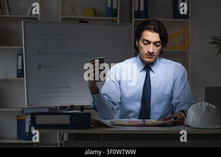 Young male architect working night at office Stock Photo