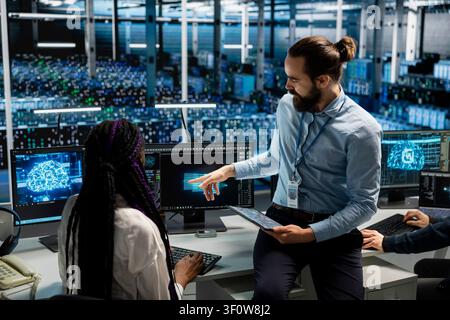 Engineer programs on a computer workstation in a data center with generative AI assistance. Stock Photo
