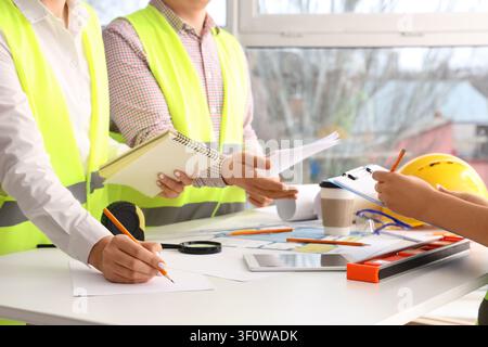 Team of constructors working at table in room Stock Photo