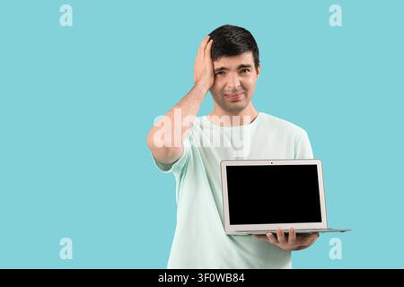Stressed male programmer with laptop on blue background Stock Photo