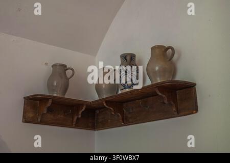 Antique Clay Jugs on Wooden Corner Shelf in a Medieval Castle Kitchen, showcasing Traditional Ceramic Pottery at Stolzenfels Germany Stock Photo