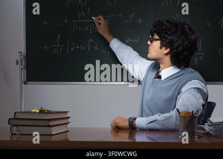 Young math teacher in front of chalkboard Stock Photo