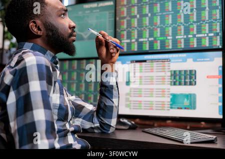 Financial analyst reviewing investment fund statistics Attentive forex stock market trader being mindful while analyzing buy and sell values. Stock Photo