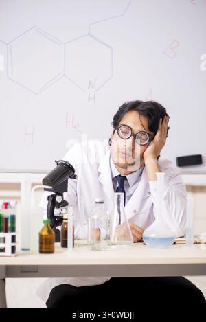 Young funny chemist in front of white board Stock Photo