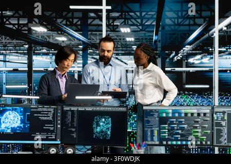 Team of server room coworkers in office running AI prediction simulations, tracking performance. Stock Photo