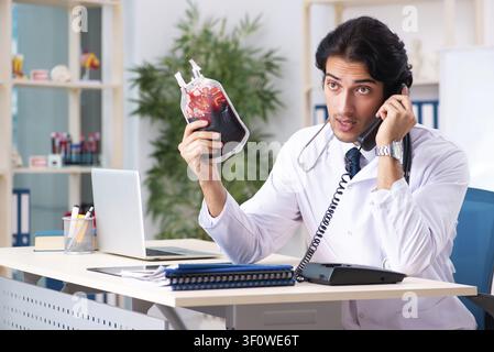 Young handsome doctor in blood transfusion concept Stock Photo