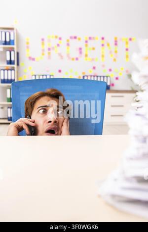Young employee suffering from excessive work Stock Photo