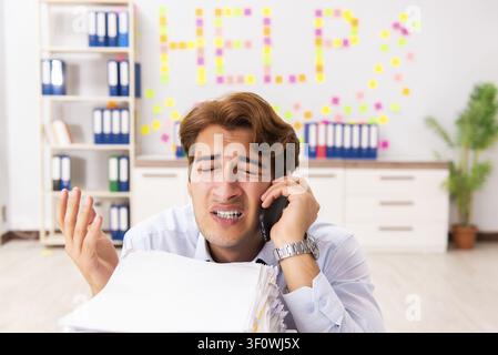 Young employee suffering from excessive work Stock Photo