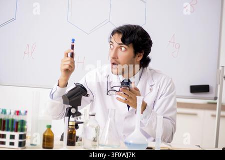 Young funny chemist in front of white board Stock Photo
