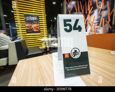 BELGRADE, SERBIA - MARCH 14, 2026: Table service number tentnside a McDonald's restaurant in Belgrade, Serbia, placed on a wooden table with receipt, Stock Photo