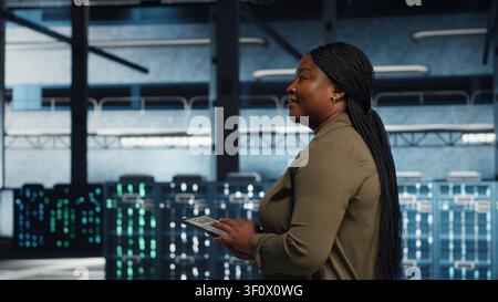Data center technician manages software updates in a server room to keep data center systems stable. Stock Photo