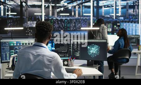 Supervisor supervising server facility systems engineer working with AI neural network models to set up hardware. Stock Photo