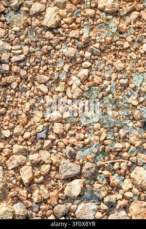 A detailed top-down view of a textured ground surface, showcasing a blend of earthy brown, orange, and beige gravel and small rocks, interspersed with Stock Photo
