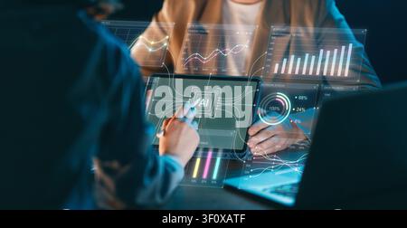 Modern business professionals collaborate and analyze complex data visualizations using an advanced artificial intelligence dashboard. The image evoke Stock Photo