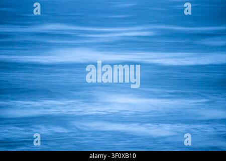 Sea texture rendered in tranquil blue tones with subtle wave lines Stock Photo