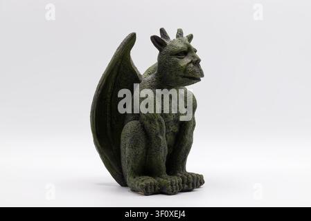 Green stone gargoyle statue with wings and horns isolated on a white background. Stock Photo