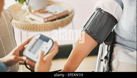 Person, nurse and blood pressure machine for monitoring heart rate, BPM or medical exam in home. Hands, healthcare worker or caregiver with arm strap Stock Photo