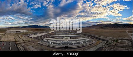 Aerial view of the Eagle Mountain data center complex featuring large industrial buildings surrounded by desert landscape under a dramatic cloudy sky Stock Photo