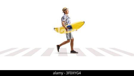 Man carrying a banana pool float at a zebra crossing isolated on white background Stock Photo