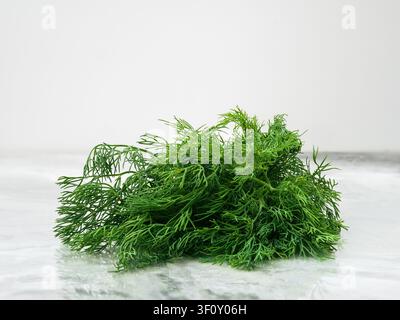 A bunch of fresh dill on a polished marble countertop. Stock Photo
