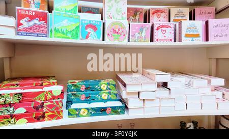 Farm shop gift display with colorful artisan matchboxes, botanical soaps and luxury incense boxes on shelves Stock Photo