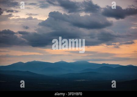 Dramatic stormy sunset over a hazy blue mountain range Stock Photo