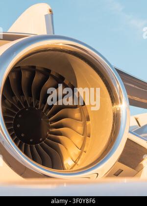 Private jet engine glowing in golden hour light Stock Photo