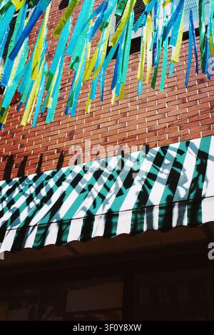 Colorful streamers hanging over a striped awning Stock Photo