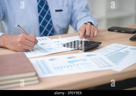 Business Professional Analyzing Financial Reports and Using Calc Stock Photo