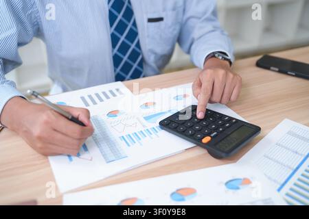 Business Accountant Analyzing Financial Reports with Calculator Stock Photo