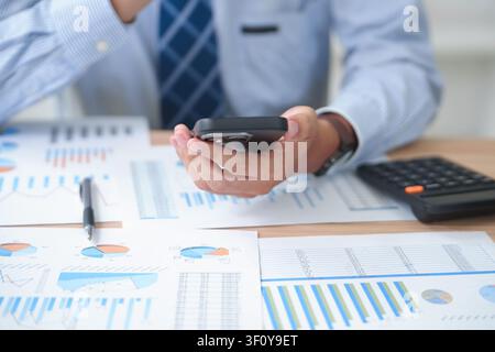 Business professional analyzing financial data with smartphone and Stock Photo