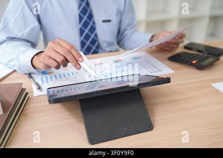 Businessman Analyzing Financial Reports with Tablet and Charts i Stock Photo