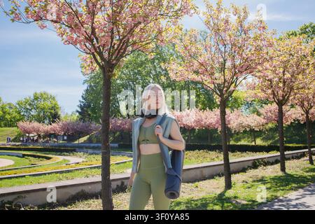 Beautiful blonde middleaged sporty woman coming on outdoor workout in Stock Photo