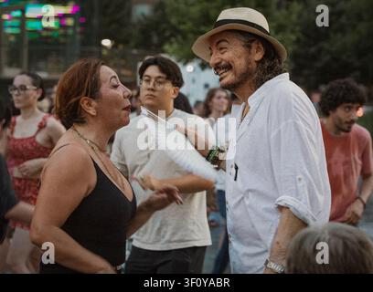 Smiling man with hat talking to woman outdoors Stock Photo