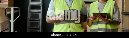 Header of warehouse workers checking inventory on tablets, coordinating stock control and logistics workflow in storage facility. Useful for supply chain, fulfillment, retail operations marketing Stock Photo