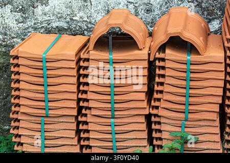 Ceramic roof tile shingles in a stack on a construction site or deposit ready to be transported and put on a building Stock Photo