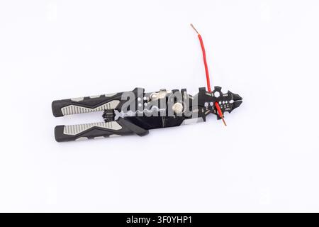 Multi-Purpose Wire Stripper Tool with Red Electrical Cable Inside Jaw Stock Photo
