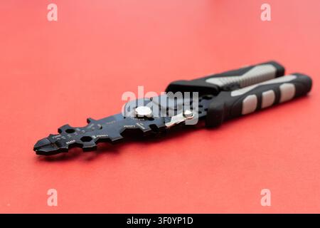 Close Up of Multi Function Wire Stripper Tool on Red Background Stock Photo
