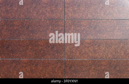 Long rectangle brown tiles for ventilated facade cladding with stone effect. Background and texture. Stock Photo