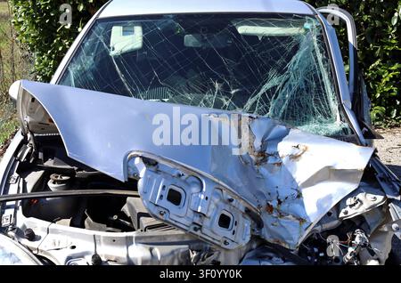 Unrecognizable car destroyed by a head-on road collision. Front view, close up. Stock Photo