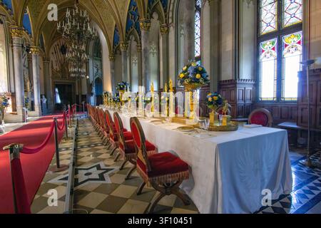 Magnificent ceremonial banquet hall inside Hohenzollern Castle featuring Gothic architecture, ornate chandeliers, stained glass, elegant dining arrang Stock Photo
