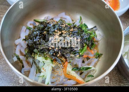 Traditional Sangju jelly bibimbap in a brass bowl with vegetables and seaweed flakes showcasing healthy authentic South Korean vegetarian dining Stock Photo