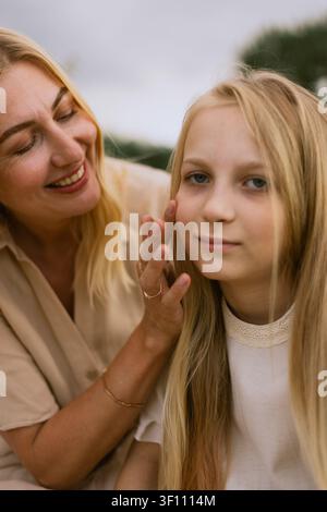 A tender moment between a mother and daughter, showcasing affection and connection in a natural setting Stock Photo